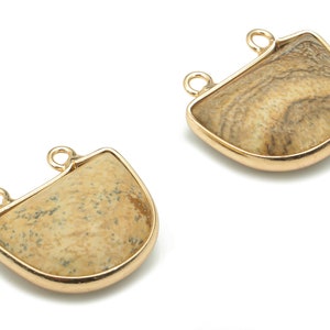 Può includere: Due ciondoli pendenti in metallo dorato con intarsi in pietra marrone e beige. Ogni ciondolo ha due anelli per il fissaggio a una collana o un braccialetto.