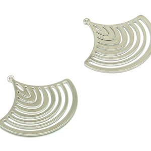 Może przedstawiać: Dwa srebrne metalowe zawieszki w kształcie wachlarza z serią koncentrycznych kół.