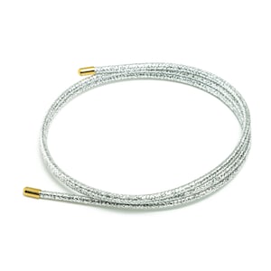 Könnte beinhalten: Eine silberne Schnur mit goldenen Endkappen. Die Schnur ist zu einem Kreis gewickelt.