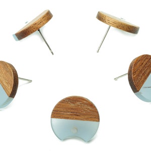 May include: A set of five wooden and resin earrings. Each earring is a half-circle shape with a wood top and a light blue resin bottom.