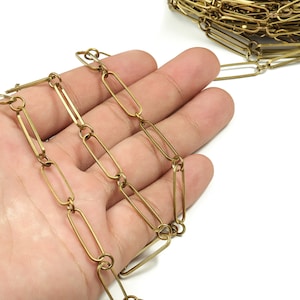 May include: A gold-toned chain made of linked oval-shaped metal pieces.