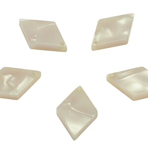 May include: Five white diamond-shaped buttons with a hole in the centre.