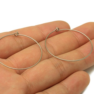 May include: A pair of silver hoop earrings. The earrings are simple and elegant, and they would be a great addition to any jewelry collection.