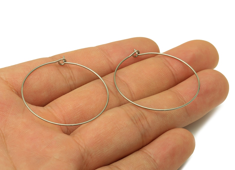May include: A pair of silver hoop earrings. The earrings are simple and elegant, and they would be a great addition to any jewelry collection.