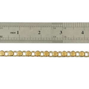 Puede incluir: Borde de cadena dorada con eslabones redondos, que mide aproximadamente 10 cm de largo. La cadena se muestra junto a una regla.