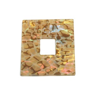 Puede incluir: Una baldosa cuadrada de nácar iridiscente con un agujero cuadrado en el centro. La baldosa tiene un patrón marrón y blanco.