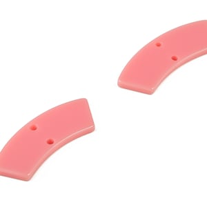 May include: Two pink plastic buttons with two holes each. The buttons are shaped like a crescent moon.