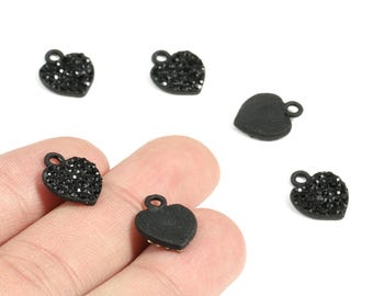 May include: Black heart-shaped charms with small loops for jewelry making. Some charms are covered in black rhinestones, while others have a smooth, matte finish. The charms are displayed against a white background.