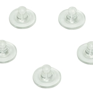 May include: Five clear plastic earring backs with a small raised bump in the center. The backs are designed to hold earrings in place.