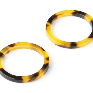 May include: Two brown and black tortoiseshell resin bangle bracelets.