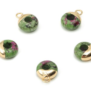 Könnte beinhalten: Fünf grüne und rosafarbene Donut-Perlen aus Edelstein mit goldenen Akzenten. Jede Perle hat ein Loch in der Mitte und eine goldene Schlaufe zum Anbringen an Schmuck.