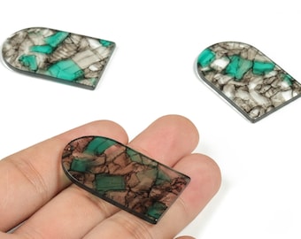 May include: Three decorative, rectangular cabochons with a rounded top. The cabochons feature a mosaic pattern of brown, gray, and turquoise pieces, set against a black border. One cabochon is held in a hand.