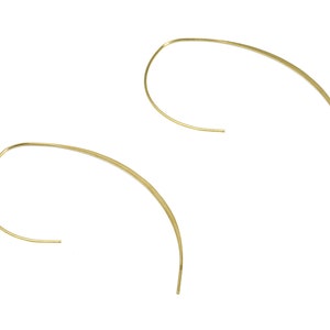 Puede incluir: Un par de pendientes de aro de oro con un diseño abierto y curvado.