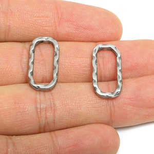 May include: Two silver-colored, hammered-texture rectangular jewelry connectors. The connectors are open in the center and have a slightly irregular shape. They are displayed against a neutral background.