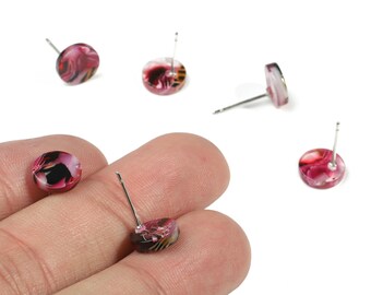 May include: A collection of small, round stud earrings with a marbled design in shades of pink, black, and white. The earrings have silver posts and are displayed on a white background.