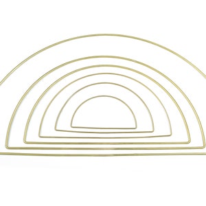 May include: Set of five gold metal hoops in a rainbow arch shape. The hoops are different sizes and are perfect for crafting.