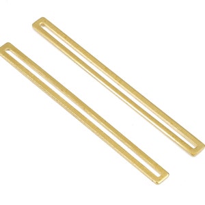 Puede incluir: Dos barras rectangulares de metal dorado con una abertura estrecha en el centro de cada barra.