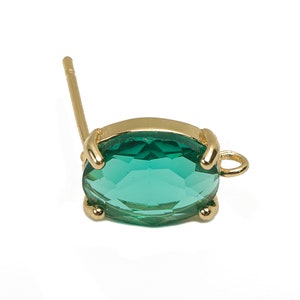 Op de afbeelding: Gouden oorbel met een groene ovale edelsteen en een lus om een ​​bedel aan te bevestigen.