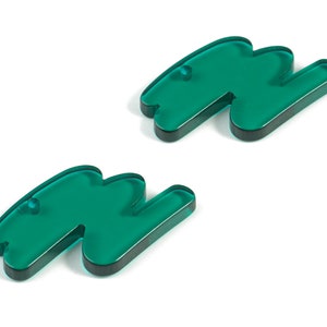 May include: Two teal green acrylic earrings shaped like a squiggly line.