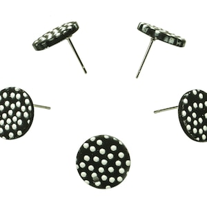 May include: Five pairs of black stud earrings with white polka dots.