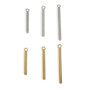 Puede incluir: Seis colgantes de barra metálica en tonos plateados y dorados. Cada barra tiene un pequeño lazo en la parte superior para sujetar a una cadena u otro componente de joyería. Las barras varían en longitud.