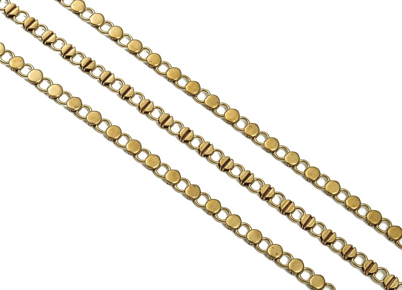 Puede incluir: Tres hebras de cadena dorada con eslabones redondos. Cada eslab&oacute;n tiene un detalle decorativo en el centro.