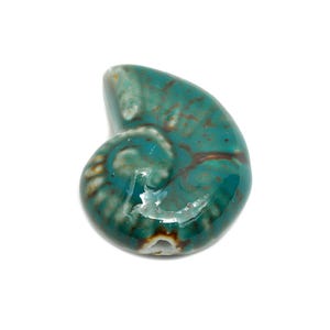 May include: A teal blue ceramic seashell charm with a white and brown swirl pattern. The seashell is glossy and has a smooth surface.
