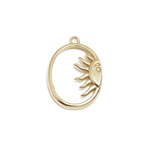 May include: A gold-colored pendant featuring a sun design within an oval frame. The sun has a detailed face and rays. The pendant has a small loop at the top for attaching to a chain or other jewelry component.