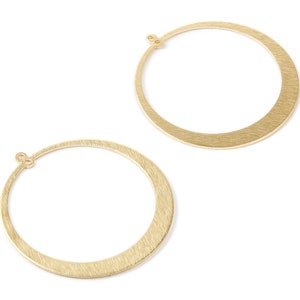 May include: Two gold-toned hoop earrings with a brushed finish. The hoops are circular and have a slightly curved shape.