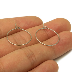 May include: A pair of silver hoop earrings. The earrings are simple and elegant, and they would be a great addition to any jewelry collection.