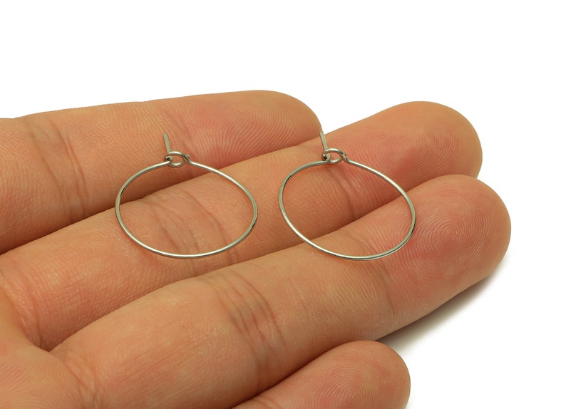May include: A pair of silver hoop earrings. The earrings are simple and elegant, and they would be a great addition to any jewelry collection.
