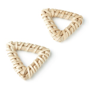 Puede incluir: Dos posavasos tejidos en forma de triángulo hechos de material natural de color beige. Los posavasos están hechos de tiras de material tejido y tienen un agujero en el centro.