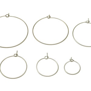 Pode incluir: Conjunto de seis brincos de argola prateados de diferentes tamanhos. As argolas são de metal e têm um design simples e clássico.