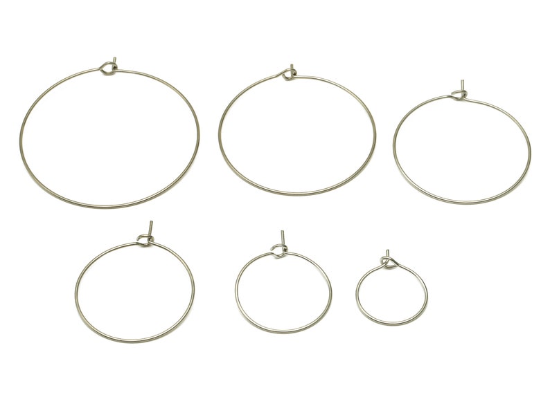 May include: Set of six silver hoop earrings of varying sizes. The hoops are made of metal and have a simple, classic design.