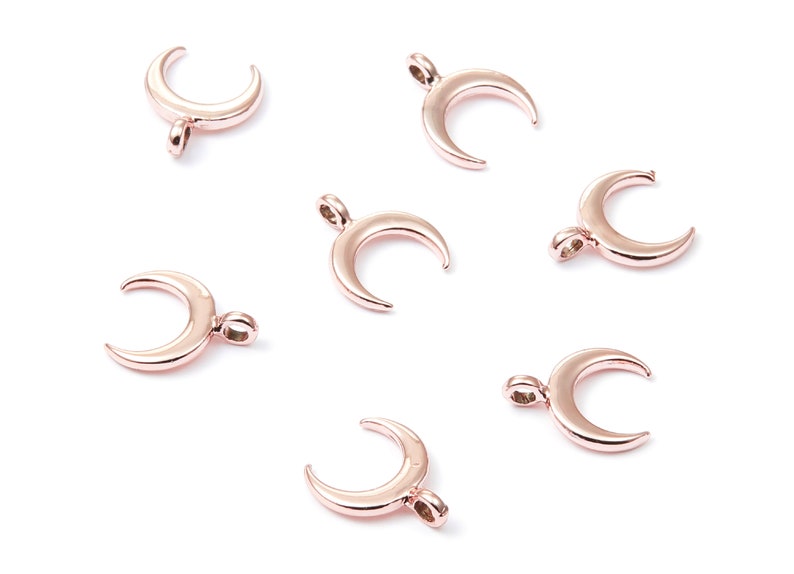 K&ouml;nnte beinhalten: Sieben ros&eacute;goldene Halbmond-Anh&auml;nger. Die Anh&auml;nger sind etwa 2,5 cm lang und haben oben eine &Ouml;se zum Anbringen an Schmuck.