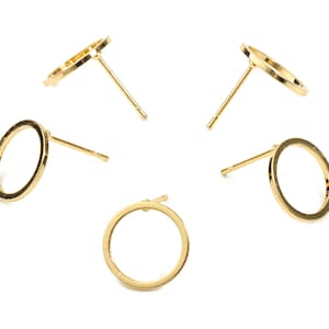 May include: Four gold-toned hoop earrings with a simple circular design. The earrings are displayed on a white background.