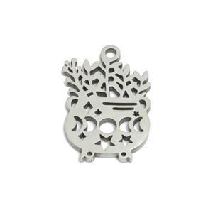 May include: Silver charm with a detailed design of a cauldron with a crescent moon and stars, surrounded by stylized plants.