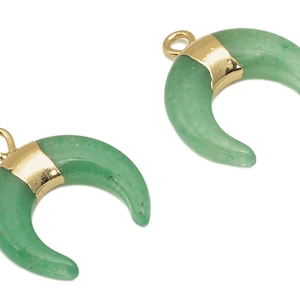 Può includere: Due ciondoli a forma di mezzaluna verde con accenti dorati. I ciondoli hanno un anello in cima per essere attaccati ai gioielli.