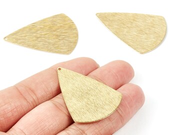 May include: Three gold-coloured, textured metal pendants in a teardrop shape. One pendant is held in a hand, while the other two are displayed separately. Each pendant has a small hole at the top for stringing.