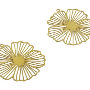 May include: Two gold metal flower-shaped charms with a delicate, intricate design. The charms have a hole at the top for attaching to jewelry or other crafts.