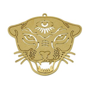 May include: A gold-colored metal pendant in the shape of a stylized panther head. The pendant features intricate cut-out details, including eyes, a third eye, and an open mouth with teeth. It has a small loop at the top for hanging.