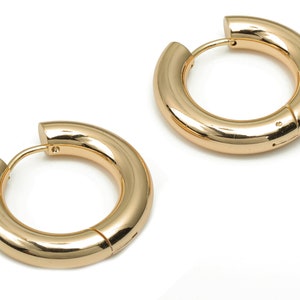 Peut inclure: Une paire de boucles d'oreilles créoles en or. Les boucles d'oreilles sont épaisses et ont une finition lisse et polie.