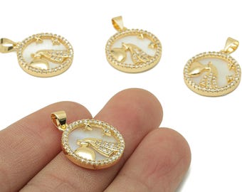 May include: Gold-tone pendants with a round, white center featuring a design of a perfume bottle and a ribbon. The pendants are encircled with small, clear crystals and stars. The pendants are shown in a hand.