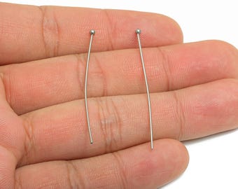 May include: Two silver-colored head pins, each with a small ball at the top. The pins are straight with a slight curve and are displayed against a neutral background.