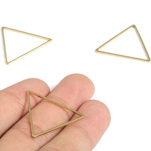 May include: Three gold triangle shaped metal hoops. The hoops are approximately 2.5 cm in diameter.