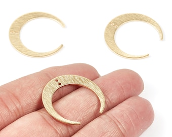 May include: Gold-colored crescent moon charms with a textured finish. Two small holes are visible near the top of each charm. One charm is held in a hand, with two others displayed above.