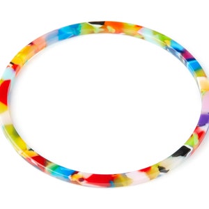 May include: A colorful bangle bracelet with a multi-colored swirl pattern. The bracelet is made of plastic and is approximately 2 inches in diameter.