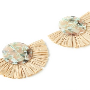 May include: A pair of beige tassel earrings with a round, marbled, light blue and brown accent piece on each earring.