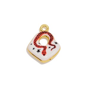Pode incluir: Um pingente em forma de diamante com borda dourada, apresentando uma superfície de esmalte branco com um gráfico de cobra vermelha e pequenos detalhes de estrelas pretas. O pingente inclui um laço dourado circular no topo para fixação.