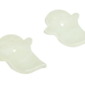 May include: Two white ghost-shaped ornaments with a hole in the center.